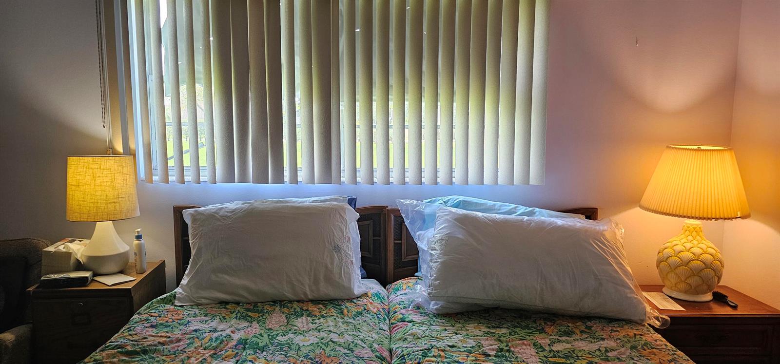 A bedroom features two twin beds with floral quilts, bedside lamps, and vertical window blinds — 263 Suffolk G, Boca Raton FL 33434, BOCA RATON, FL