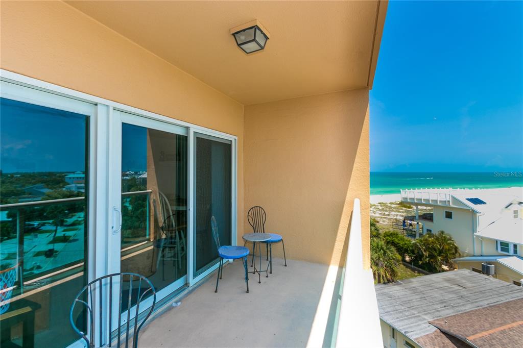 A balcony with metal chairs overlooks a beach and the ocean — 880 MANDALAY AVENUE UNIT N412, CLEARWATER, FL