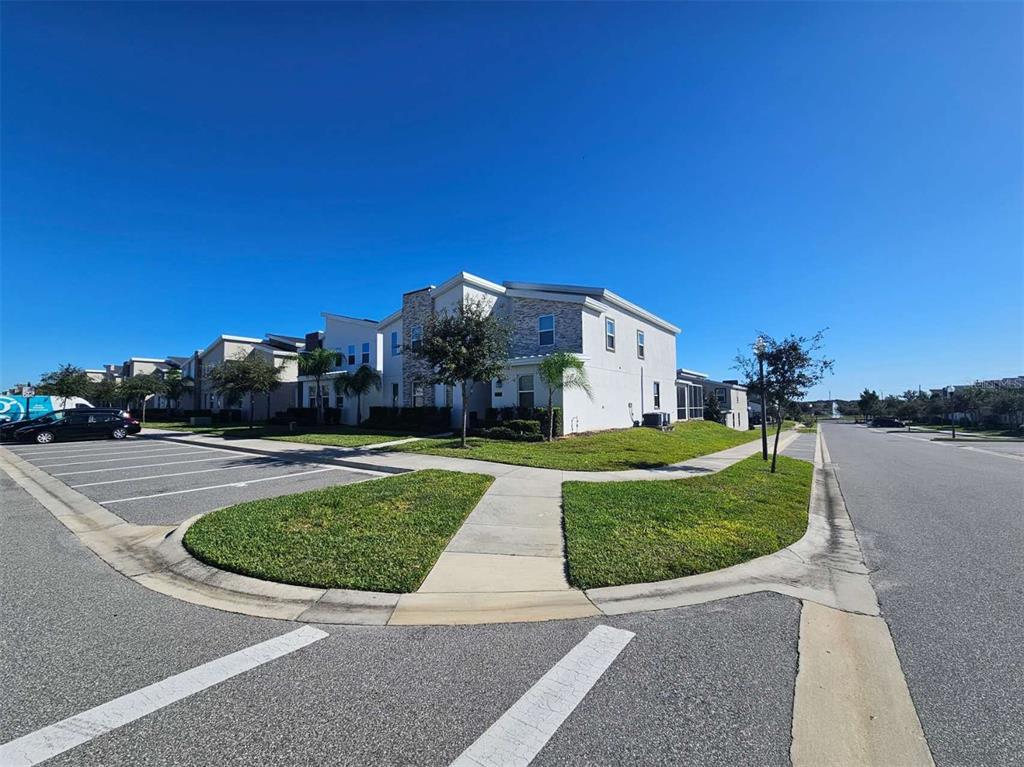 A multi-story residential building with a stone facade stands next to a parking lot — 1265 CHALLENGE DRIVE, DAVENPORT, FL