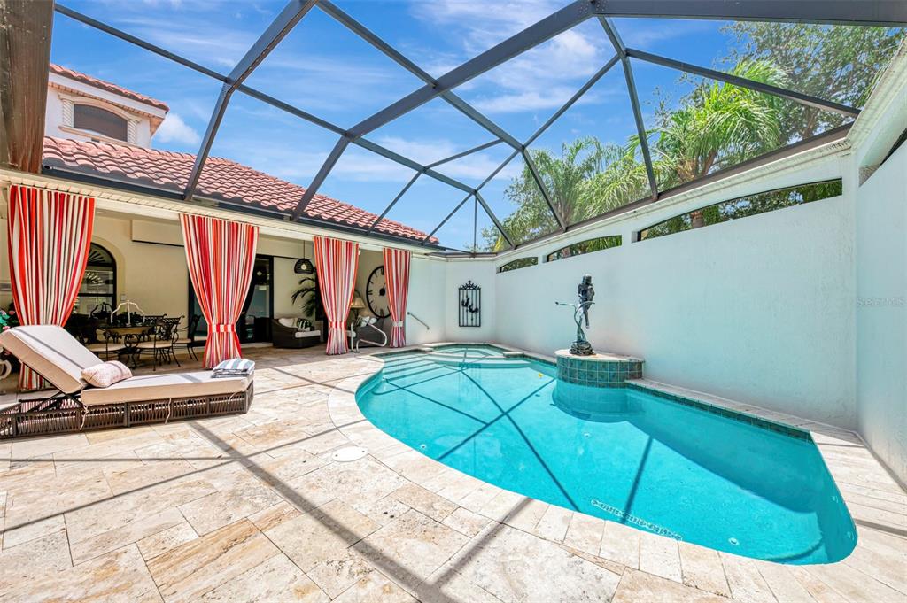 A covered outdoor patio features a dining set, lounge chairs, a ceiling fan, and pool access — 256 PENSACOLA ROAD, VENICE, FL