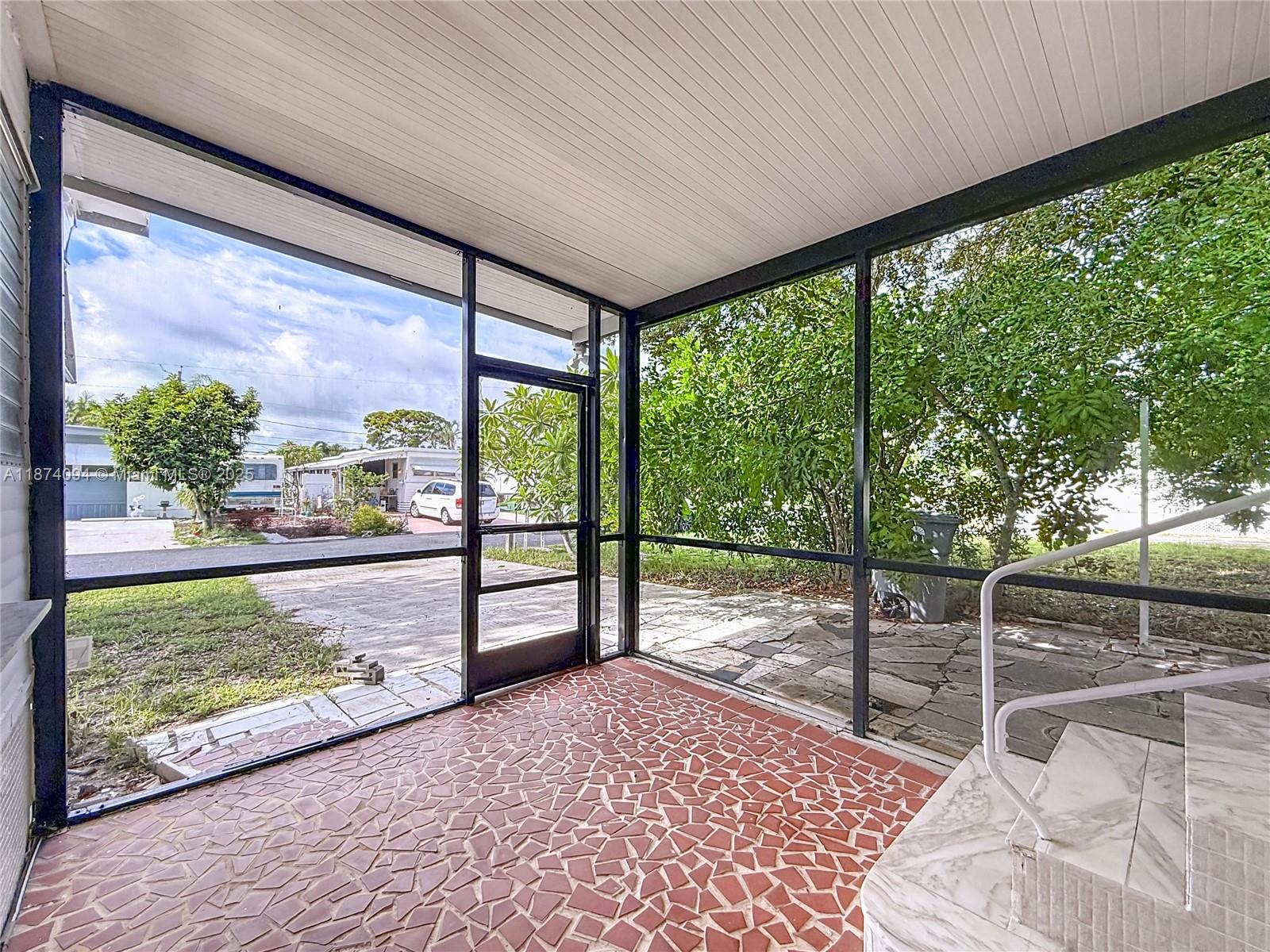 A screened-in porch features a red mosaic tile floor and a view of the outdoors — 4165 S 88th Ct S, Boynton Beach FL 33436, BOYNTON BEACH, FL