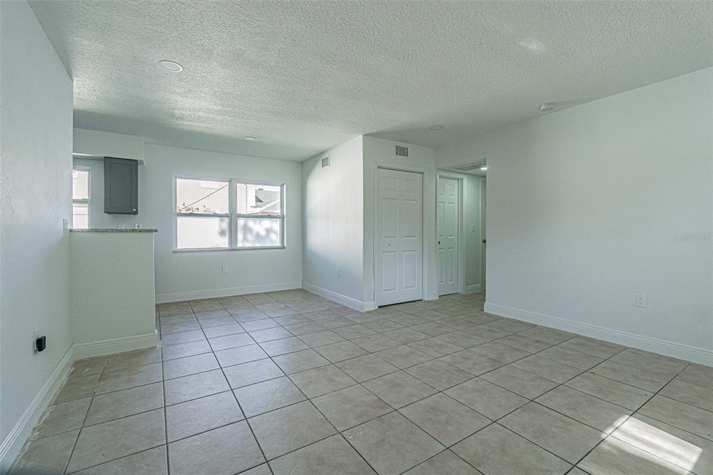 An empty room with light-colored tile flooring, white walls, and two white interior doors — 558 CLEARWATER LARGO ROAD N UNIT 1, LARGO, FL