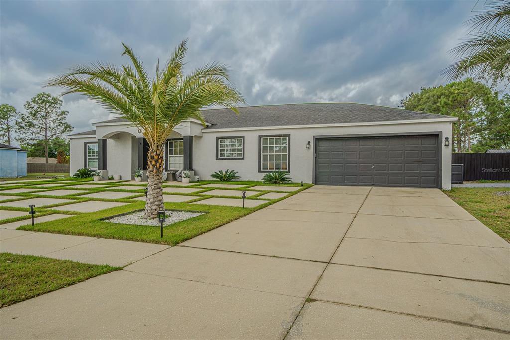 A single-story house with a gray exterior, a two-car garage, and a paved driveway — 12121 COLONIAL ESTATES LANE, RIVERVIEW, FL