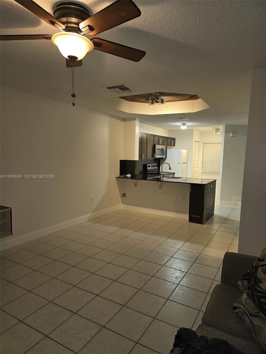 This room features a tiled floor, a ceiling fan, and an open kitchen with counters — 14272 SW 121st Pl # 9, Miami FL 33186, MIAMI, FL