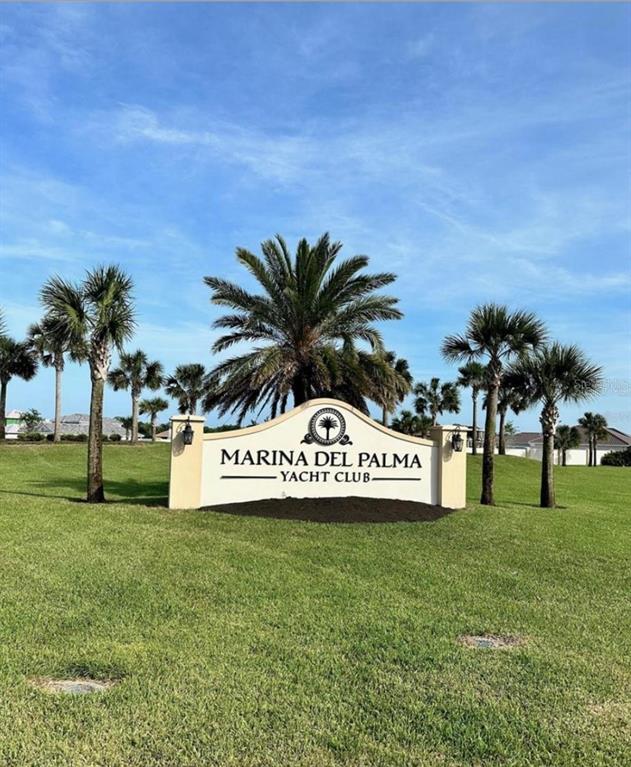 A sign for Marina Del Palma Yacht Club stands on a grassy lawn with palm trees — 62 DEL PALMA DRIVE, PALM COAST, FL