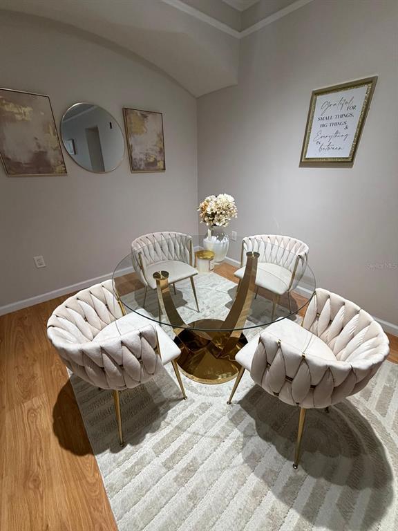 A dining area features a glass-topped table with a gold base and four upholstered chairs — 12024 VILLANOVA DRIVE UNIT 105, ORLANDO, FL