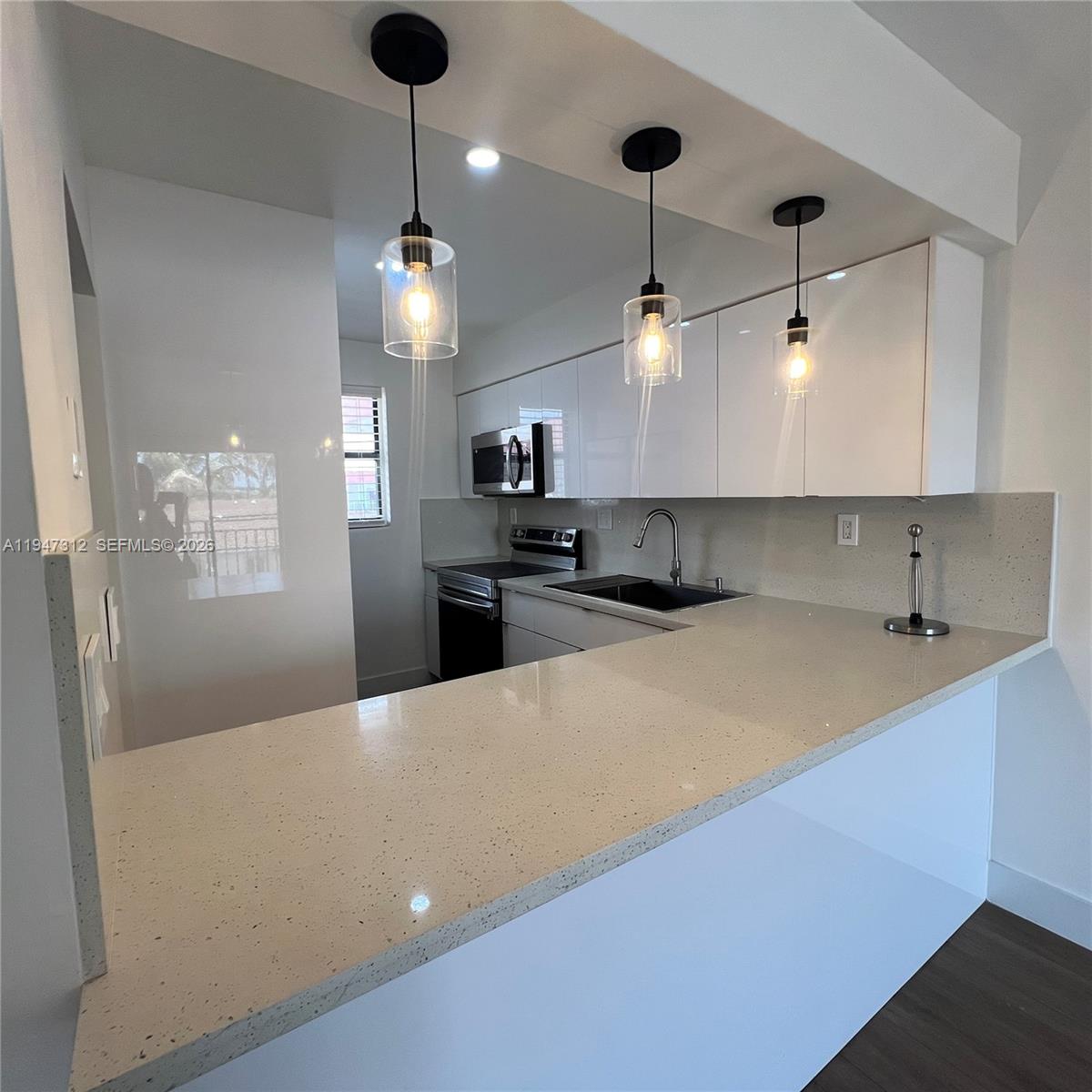 A stainless steel kitchen sink with a drying rack and faucet set in quartz countertops — 8425 NW 8th St # 406, Miami FL 33126, MIAMI, FL