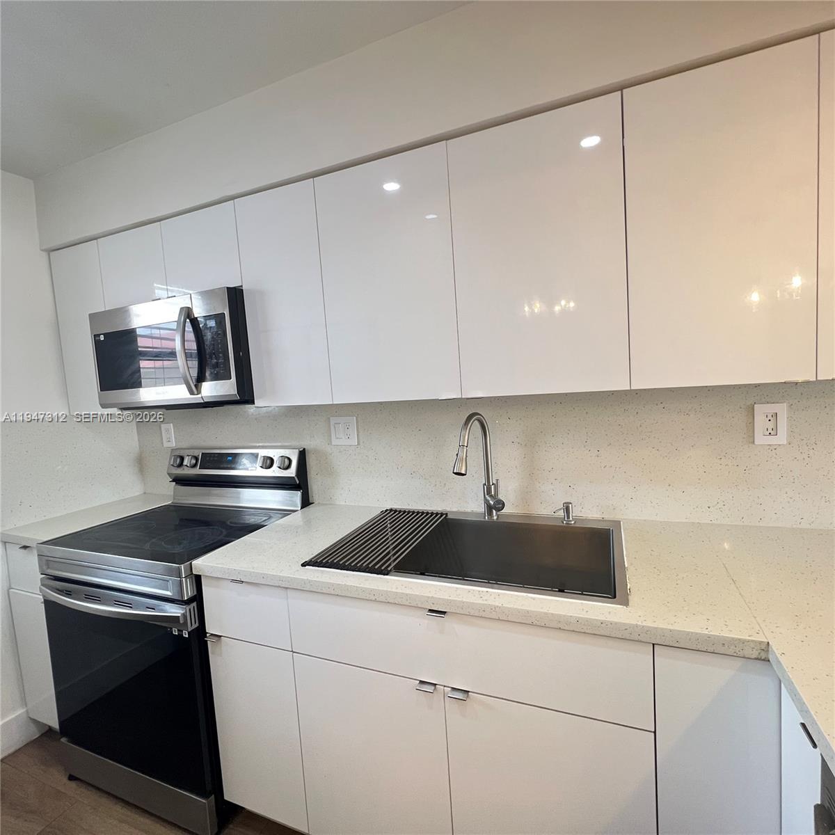 A stainless steel side-by-side refrigerator stands next to white floor-to-ceiling cabinets in a kitchen — 8425 NW 8th St # 406, Miami FL 33126, MIAMI, FL