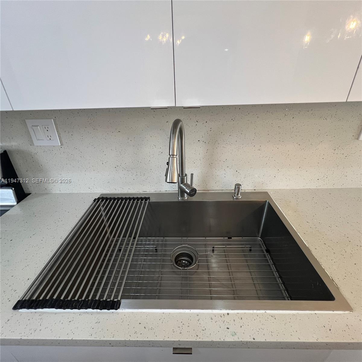 A kitchen features white cabinets, a stainless steel dishwasher, and three hanging pendant lights — 8425 NW 8th St # 406, Miami FL 33126, MIAMI, FL