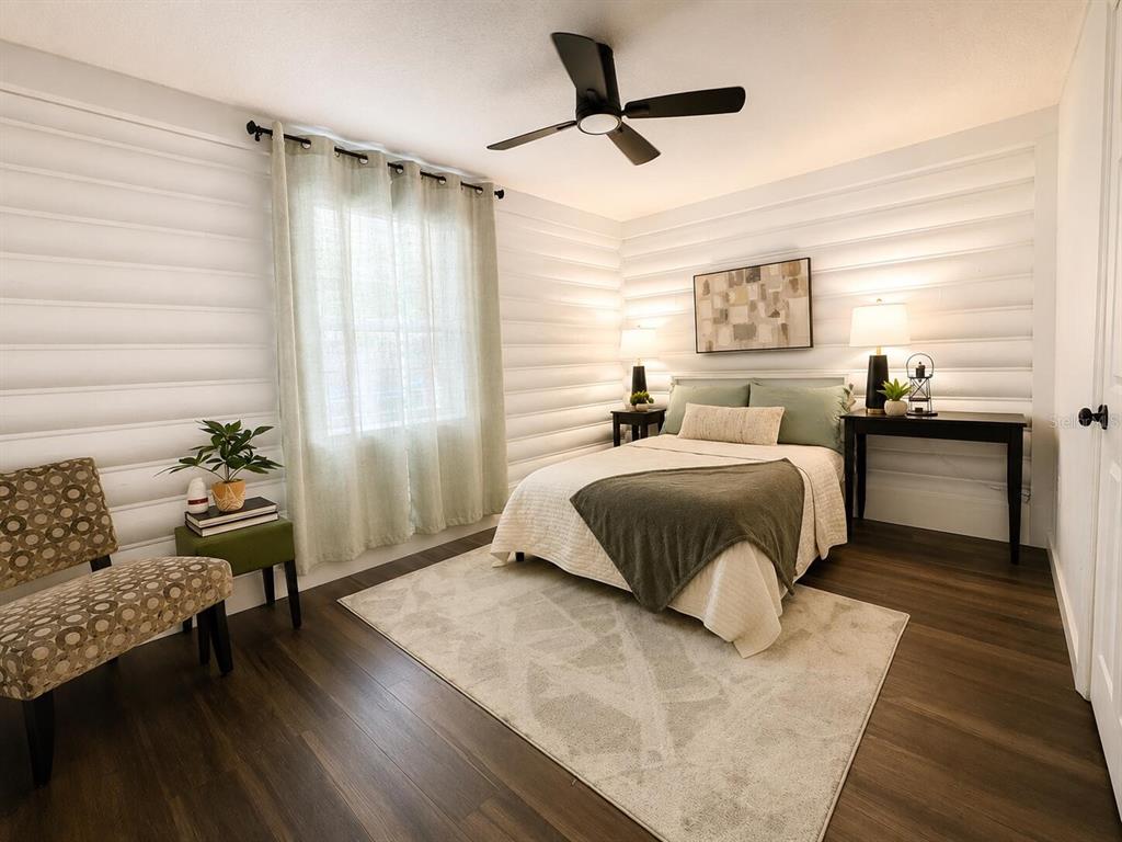 A bedroom with white log walls, a ceiling fan, a bed, and a patterned chair — 6306 HILL ROAD, ORLANDO, FL
