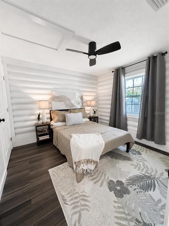 A bedroom features white log-style walls, dark wood flooring, a ceiling fan, and a bed — 6306 HILL ROAD, ORLANDO, FL