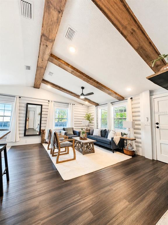 A living room features vaulted ceilings with exposed wooden beams, log walls, and dark flooring — 6306 HILL ROAD, ORLANDO, FL