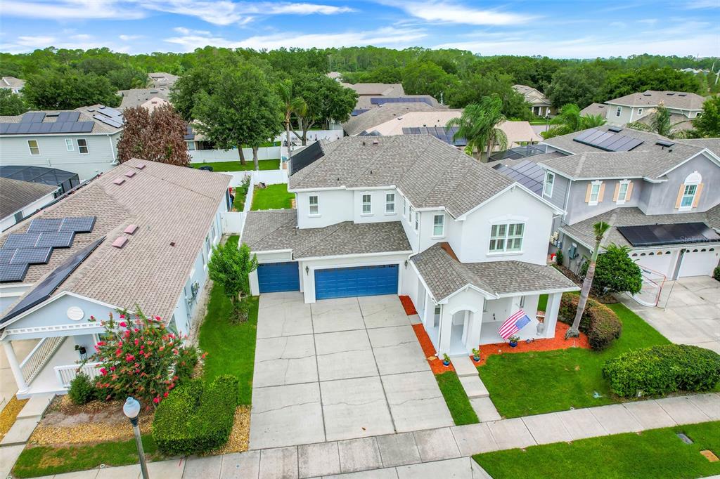An aerial view shows a two-story suburban house with a blue garage and driveway — 7242 LONDALE BOULEVARD, WINDERMERE, FL