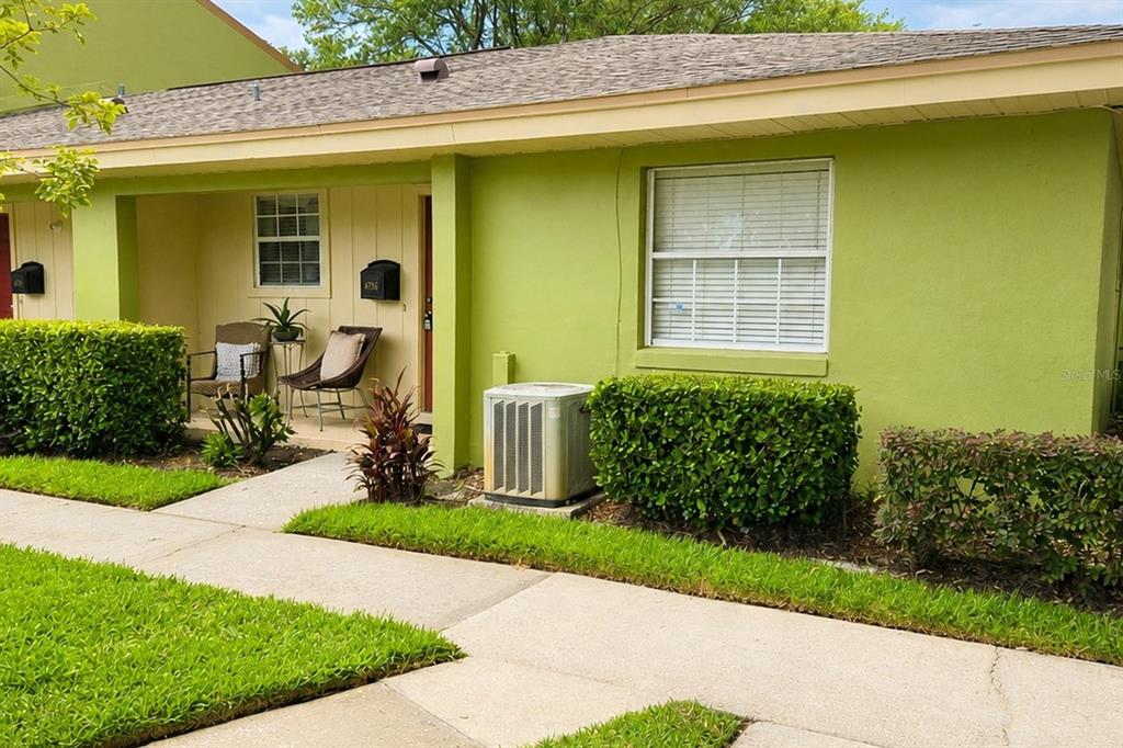 A lime green single-story house exterior features a covered entryway, a window, and landscaping — 4756 TANGERINE AVENUE UNIT 4756, WINTER PARK, FL