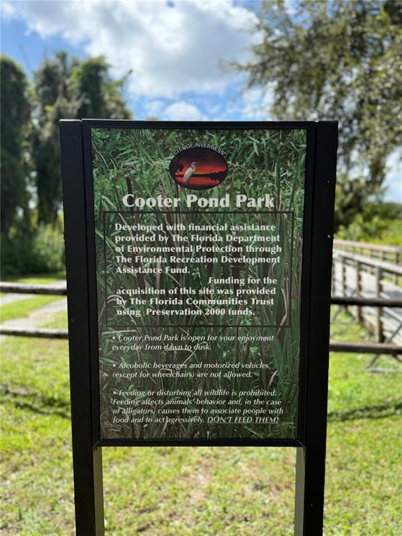 A sign for Cooter Pond Park stands outdoors in a grassy area near a wooden walkway — 326 W HOMEWAY LOOP, CITRUS SPRINGS, FL