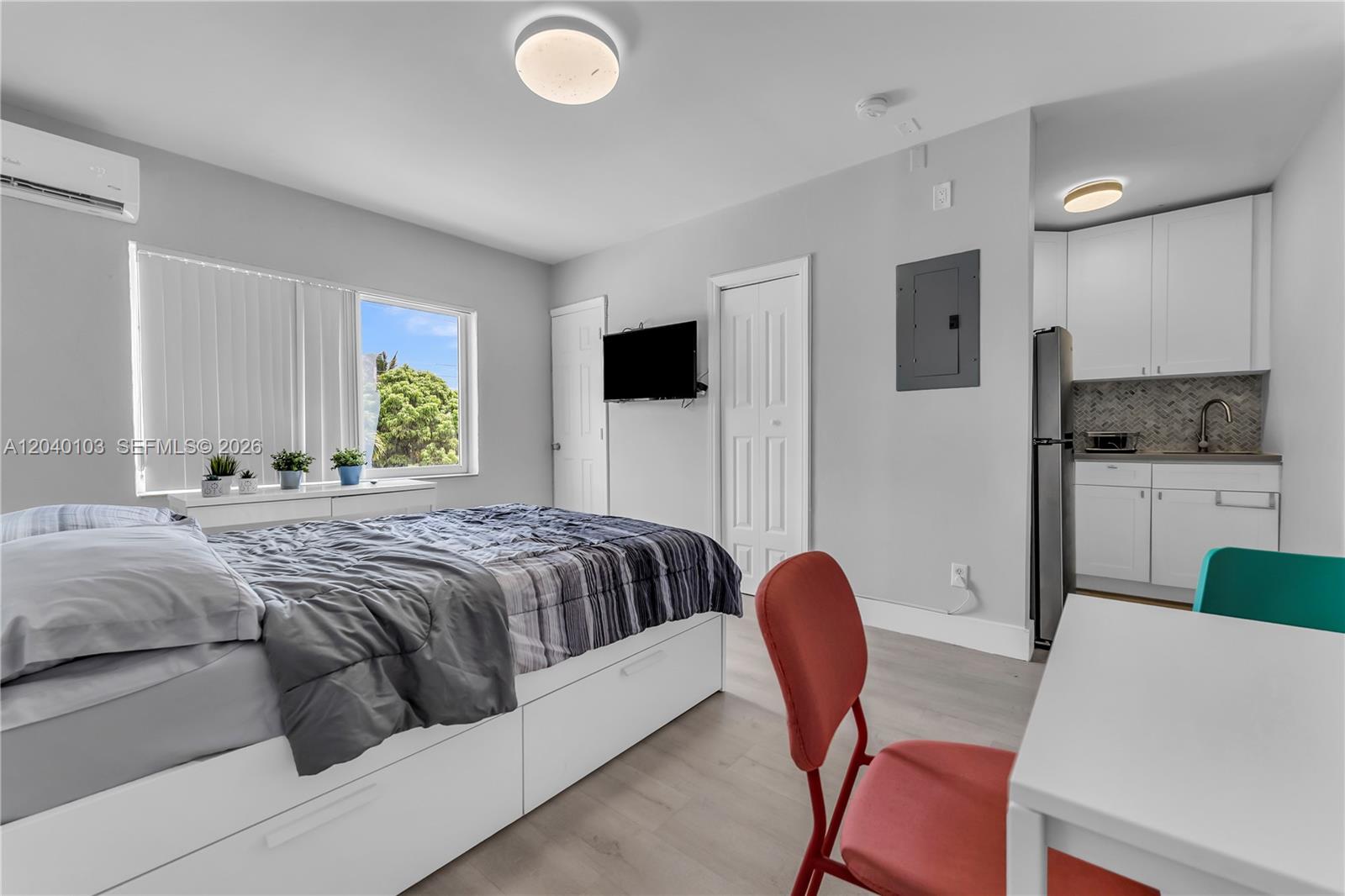 A studio apartment features a bed, a small kitchen area, and a desk with chairs — 6647 SW 59th Pl # 208, South Miami FL 33143, SOUTH MIAMI, FL