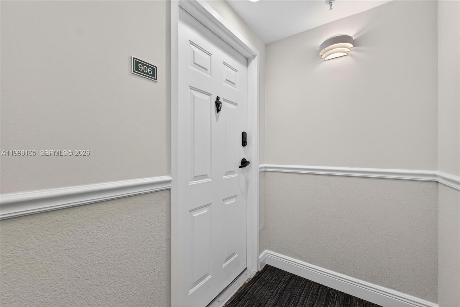 A white door with a number 906 sign is set in a hallway with beige walls — 2301 SW 27th Ave # 906, Miami FL 33145, MIAMI, FL