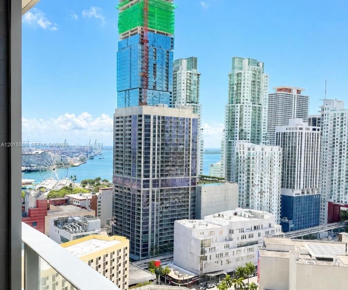 An elevated view of a city skyline featuring multiple high-rise buildings and a waterfront harbor — 121 NE 5th St # 2705, Miami FL 33132, MIAMI, FL