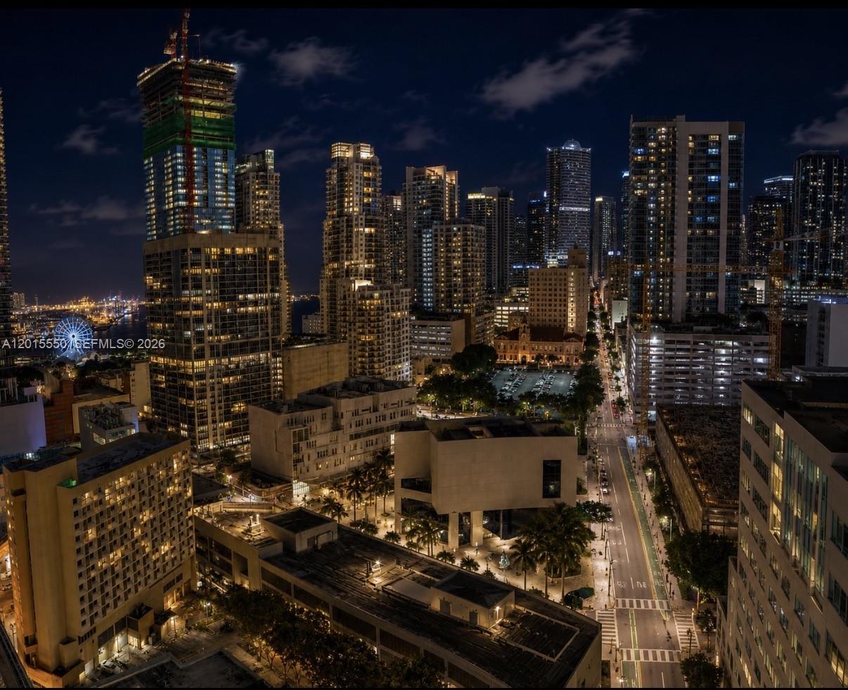 An elevated night view of a dense city skyline featuring numerous illuminated high-rise buildings — 121 NE 5th St # 2705, Miami FL 33132, MIAMI, FL