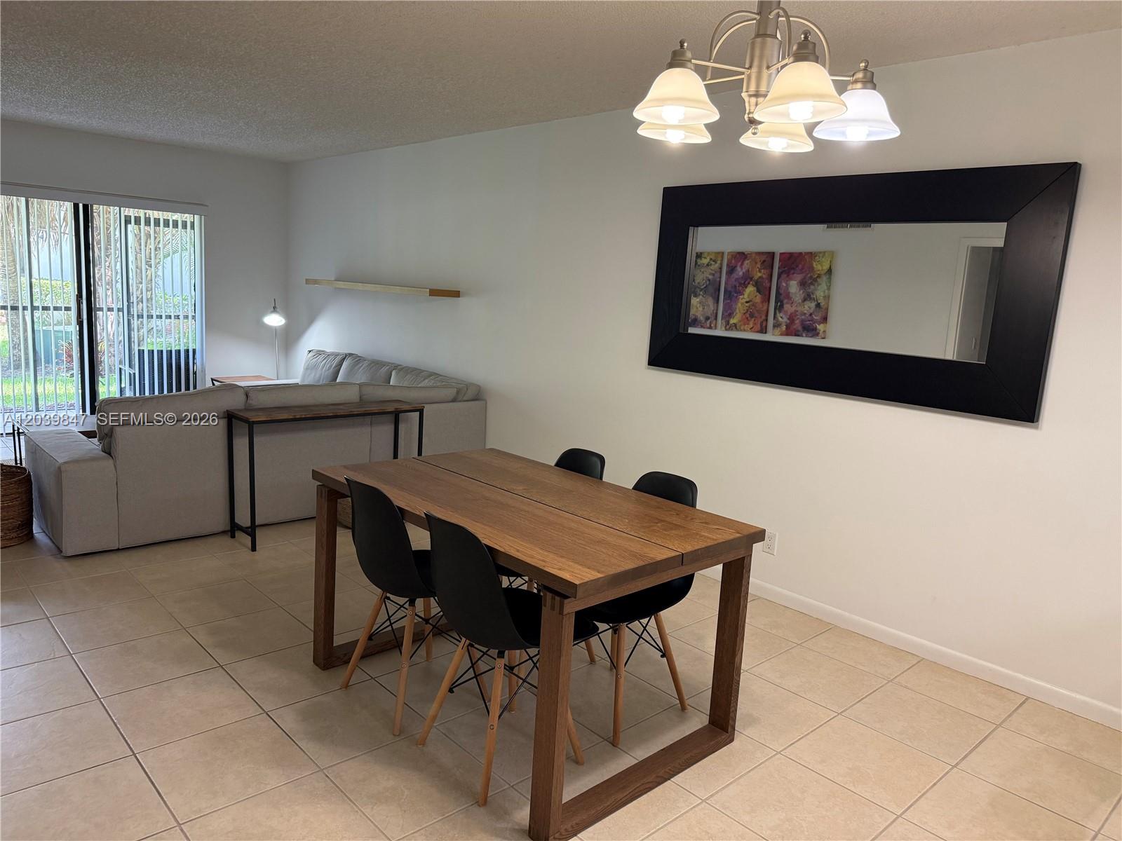 A dining area with a wooden table and chairs sits adjacent to a living room — WESTON, FL