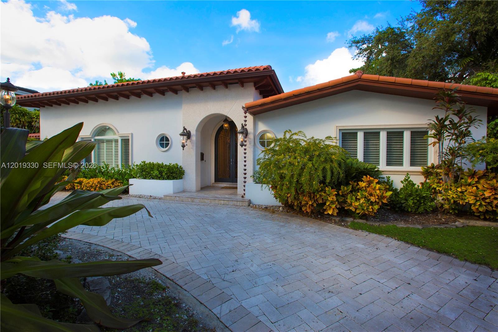 A single-story house with a white stucco exterior, terracotta roof, and a paved driveway — 125 W Sunrise Ave, Coral Gables FL 33133, CORAL GABLES, FL