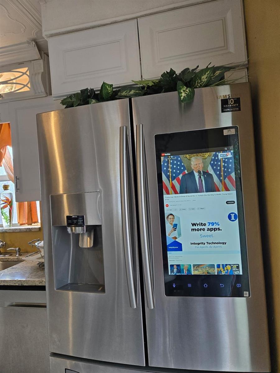 A stainless steel Samsung smart refrigerator with a built-in touchscreen display sits in a kitchen — 3200 NW 5th Terrace # 24, Pompano Beach FL 33064, POMPANO BEACH, FL