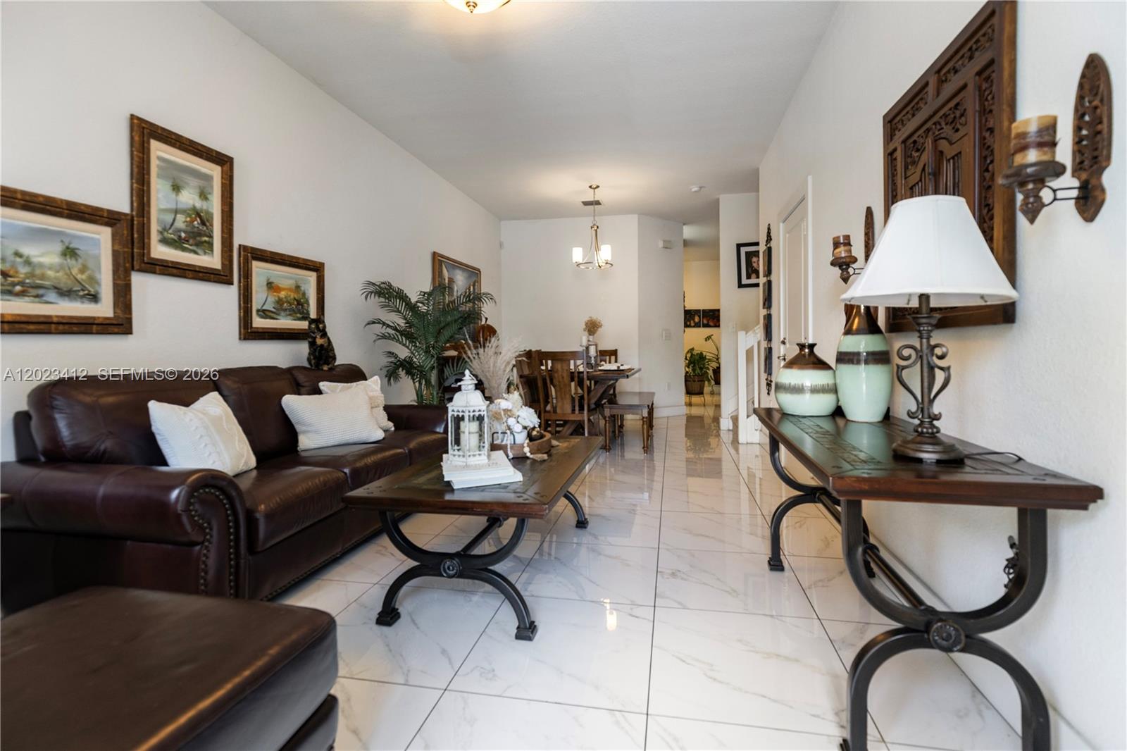 A living room and dining area feature white tile floors, dark wood furniture, and wall art — 12704 SW 131st Ter, Miami FL 33186, MIAMI, FL