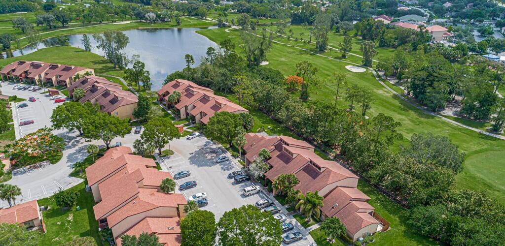 An aerial view of multi-family residential buildings with red roofs situated next to a golf course — 405 Lakeview Drive E, Royal Palm Beach FL 33411, ROYAL PALM BEACH, FL