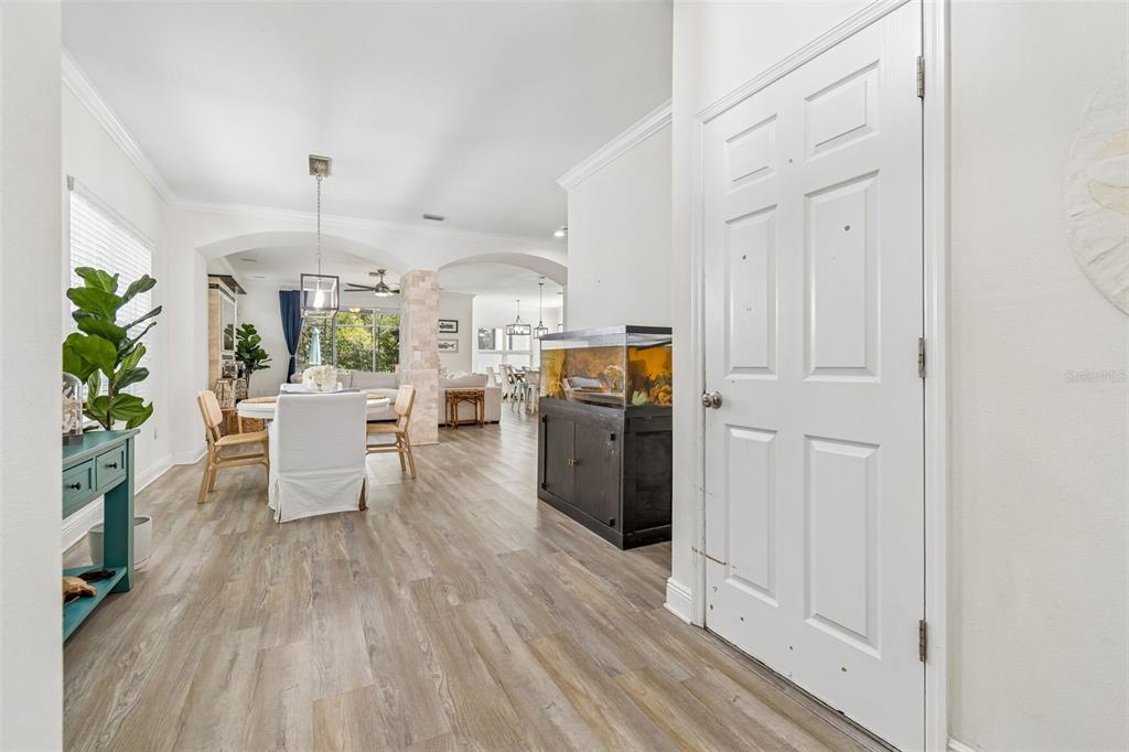 A view from an entryway looking into a dining area with wood-look flooring and furniture — 16214 BAYBERRY VIEW DRIVE, LITHIA, FL