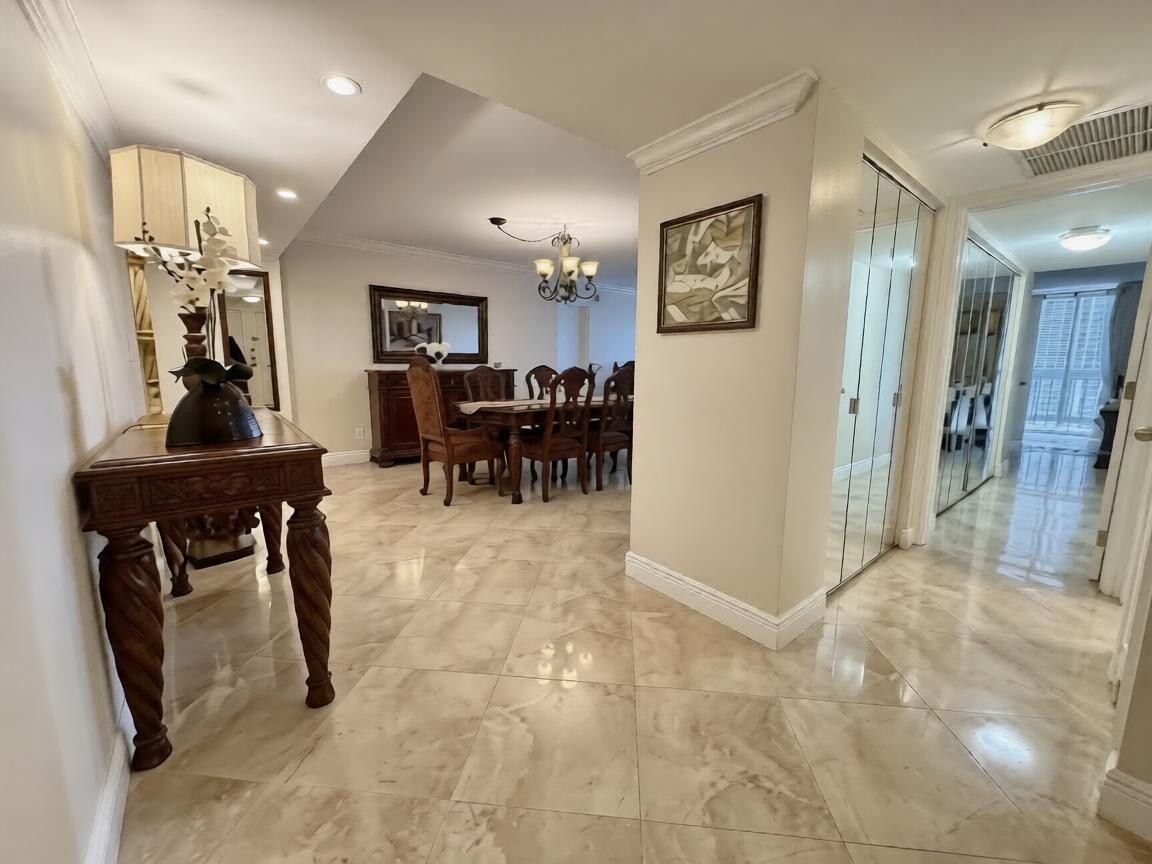 A foyer with a wooden console table leads to a dining room with marble tile flooring — 1370 S Ocean Boulevard # 603, Pompano Beach FL 33062, POMPANO BEACH, FL