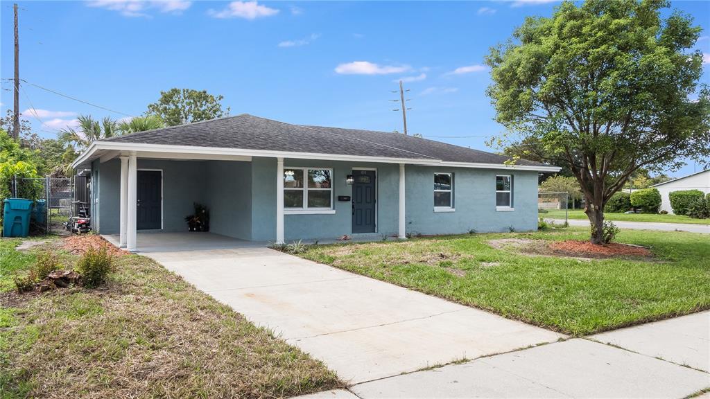 A single-story blue house with a carport and a concrete driveway under a blue sky — 4294 NIMONS STREET, ORLANDO, FL