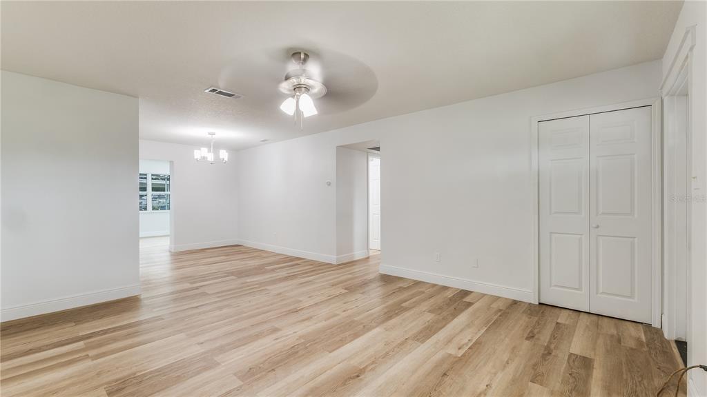An empty room with light wood-look flooring, white walls, a ceiling fan, and closet doors — 4294 NIMONS STREET, ORLANDO, FL