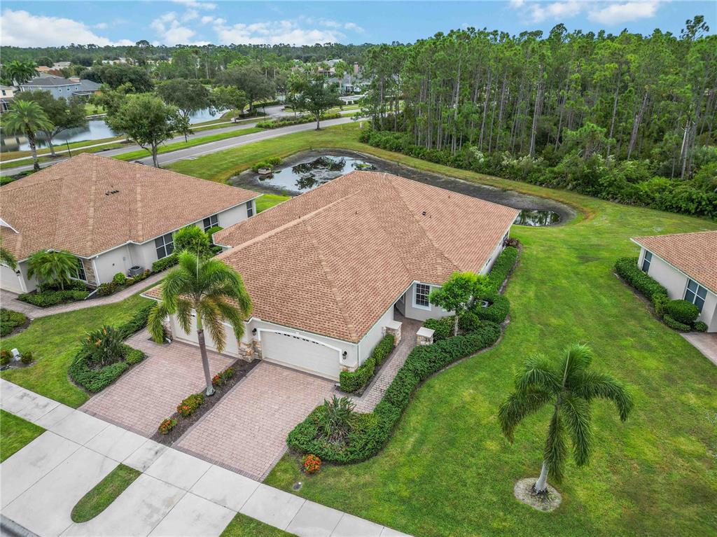 An open-concept living and dining area features tile flooring, a chandelier, and sliding glass doors — 1914 SCARLETT AVENUE, NORTH PORT, FL