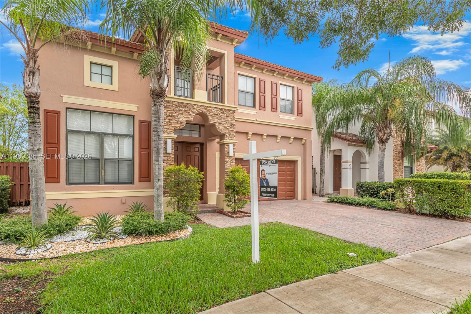 A two-story stucco house with a stone facade, a brick driveway, and a for-rent sign — 642 SE 37th PL, Homestead FL 33033, HOMESTEAD, FL