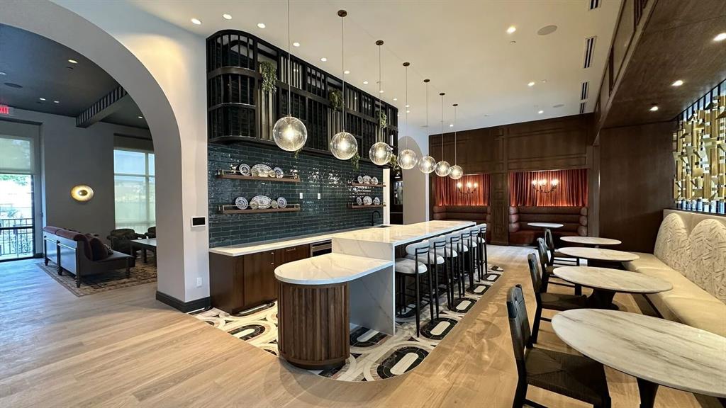 A modern lounge area features a marble-topped bar, pendant lighting, and dark wood cabinetry — 1620 NUCCIO PARKWAY UNIT A5A, TAMPA, FL