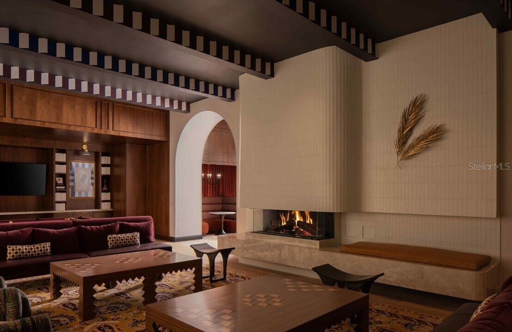 A living room features a modern fireplace, wood paneling, and a dark coffered ceiling — 1620 NUCCIO PARKWAY UNIT A5A, TAMPA, FL