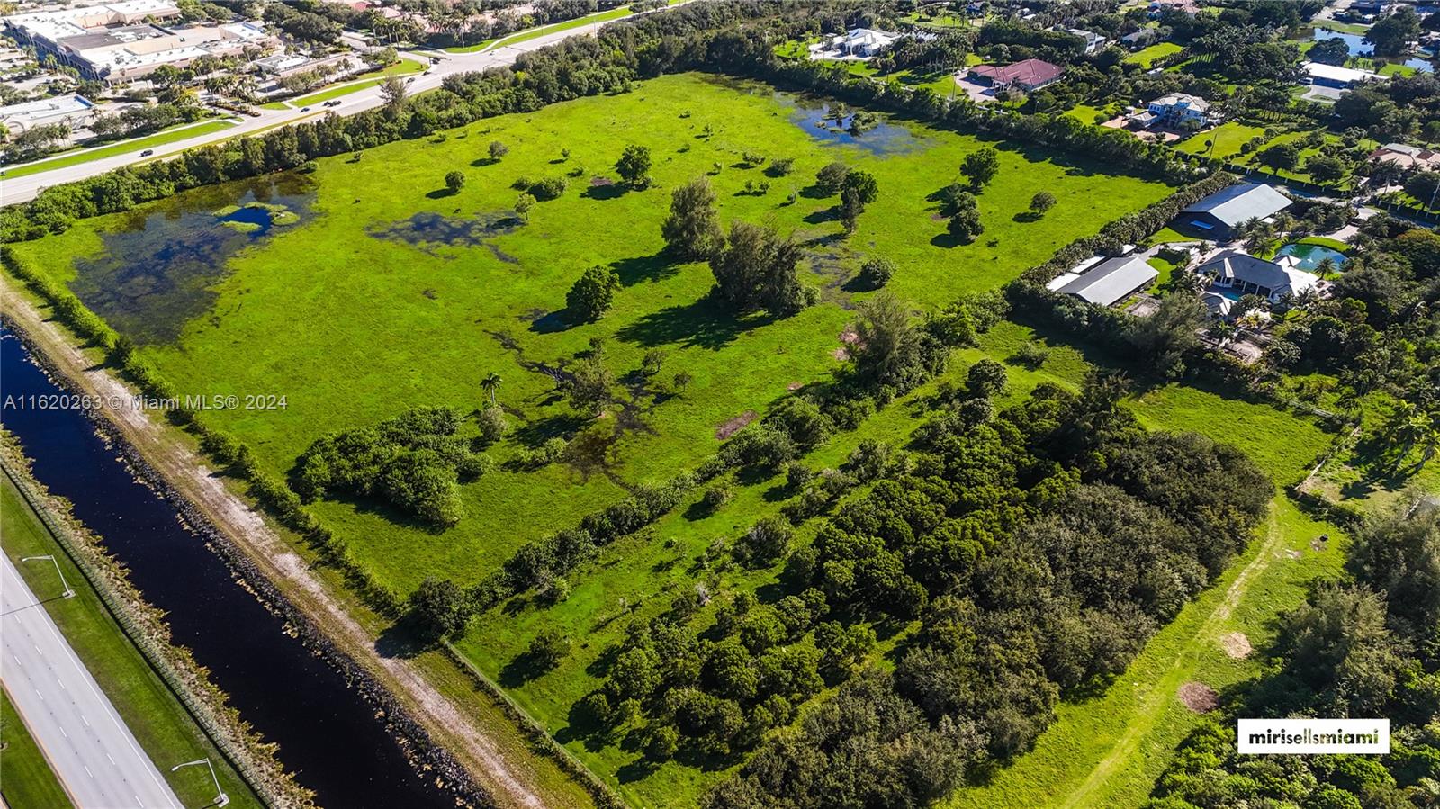 An aerial view shows a large, grassy, partially wooded lot adjacent to a canal and road — 6701 SW 124th Ave, Southwest Ranches FL 33330, SOUTHWEST RANCHES, FL