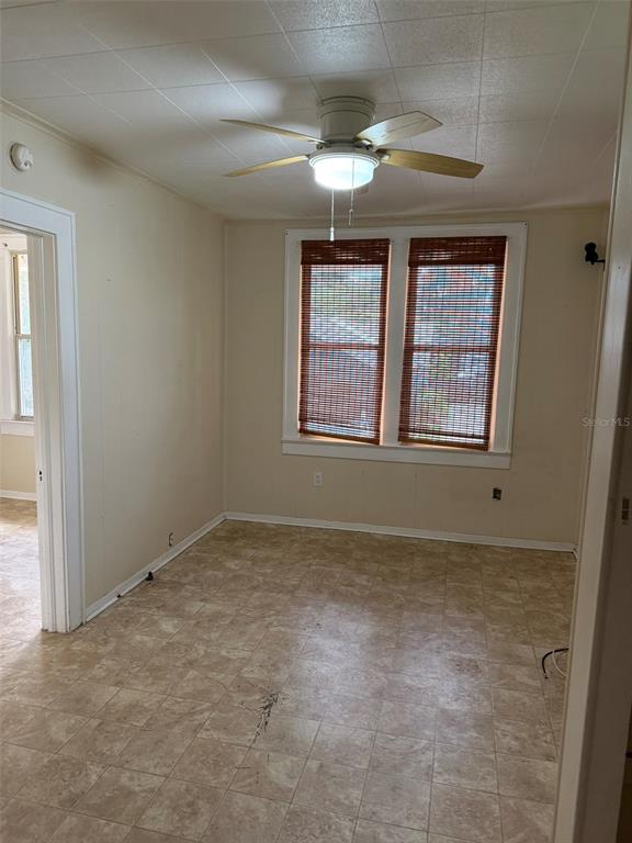 An empty room features a ceiling fan, two windows with bamboo shades, and tile flooring — 639 E AMELIA STREET, ORLANDO, FL