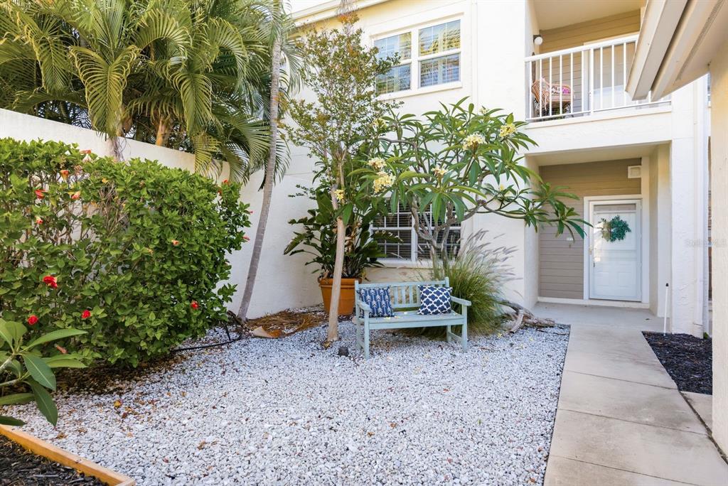 An exterior view of a residential building entrance with a white door and concrete porch — 11510 SHIPWATCH DRIVE UNIT 1372, LARGO, FL