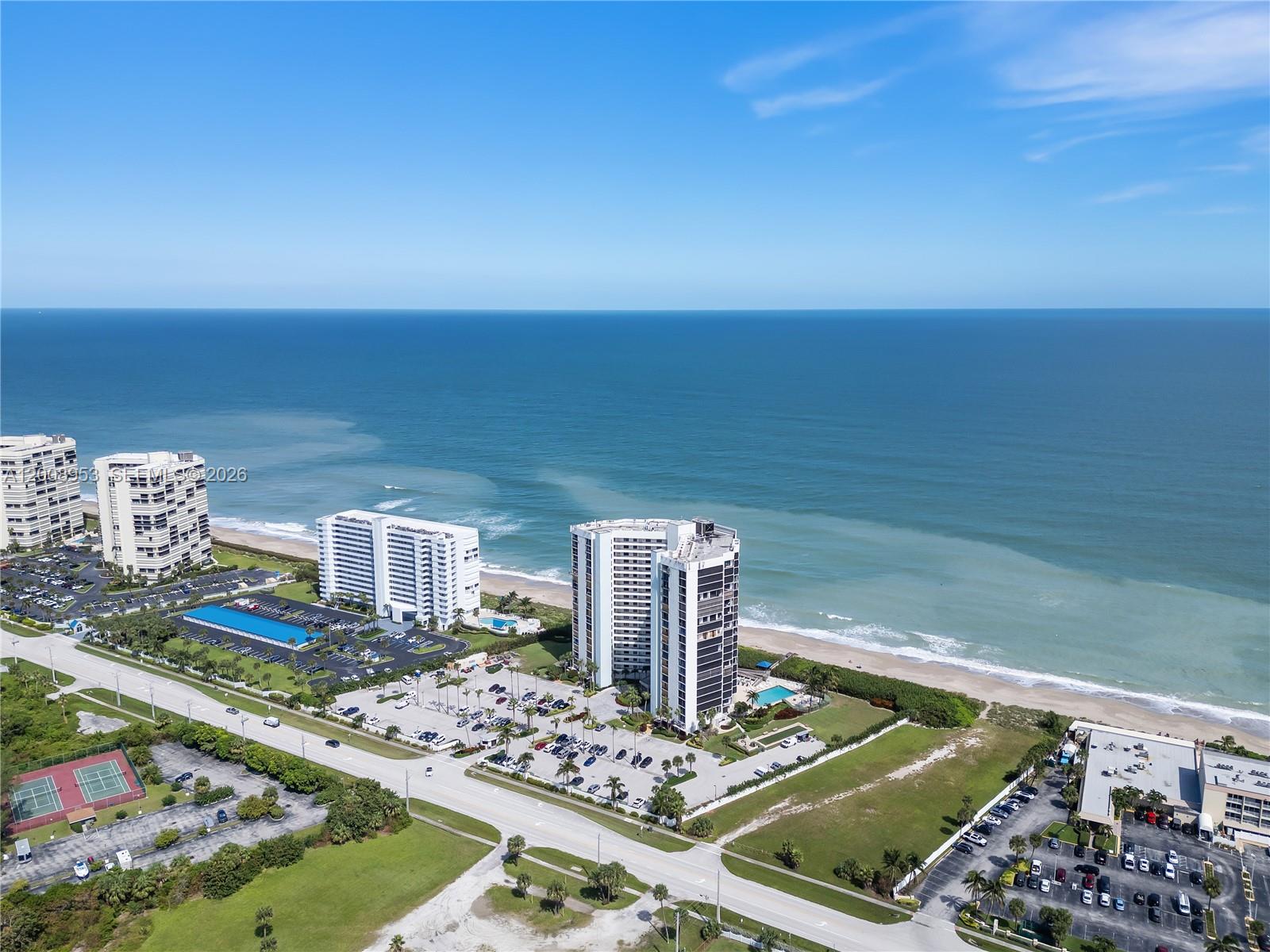 An aerial view shows several high-rise residential buildings situated along a sandy beach — 9650 S Ocean Dr # 1509, Jensen Beach FL 34957, JENSEN BEACH, FL