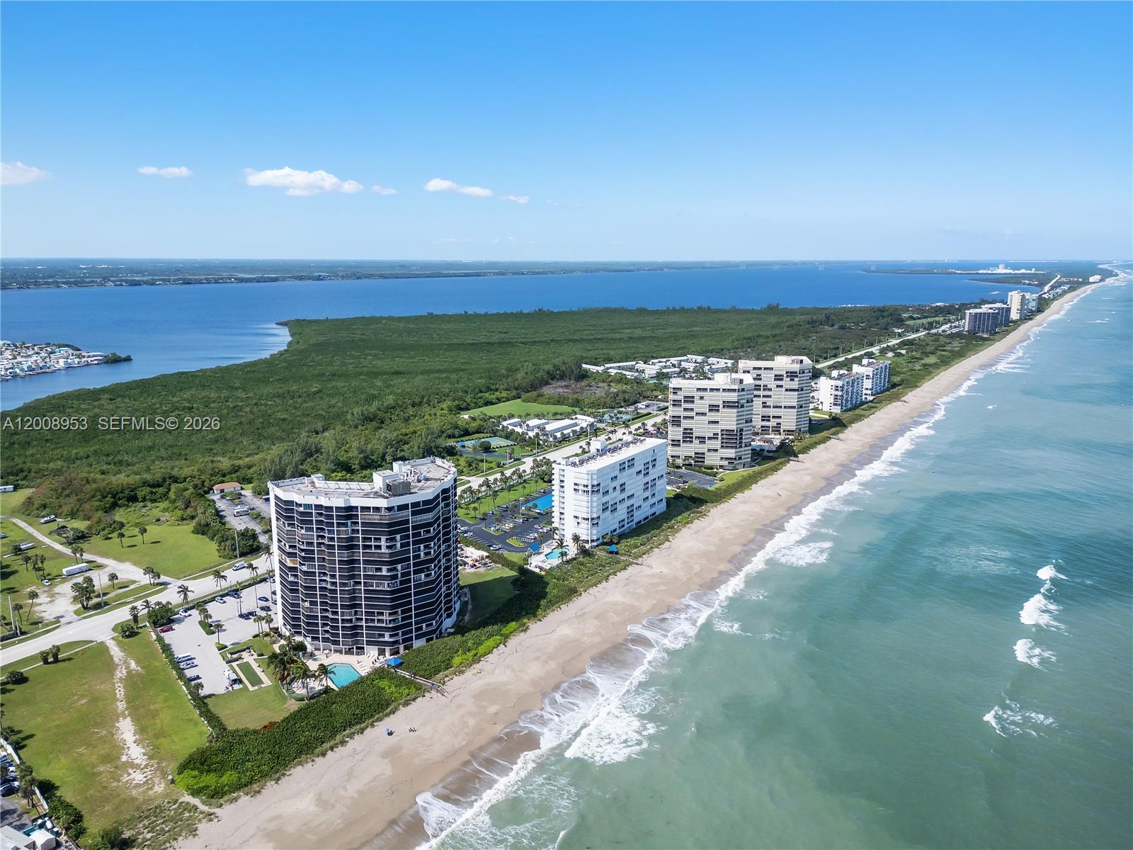 An aerial view shows several high-rise residential buildings situated along a sandy beach coastline — 9650 S Ocean Dr # 1509, Jensen Beach FL 34957, JENSEN BEACH, FL