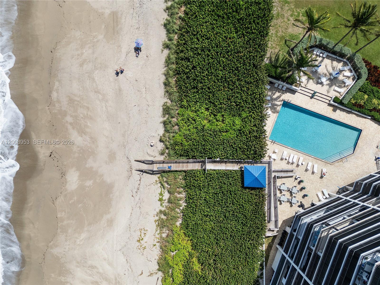 An aerial view shows a beach, a swimming pool, a wooden walkway, and a building — 9650 S Ocean Dr # 1509, Jensen Beach FL 34957, JENSEN BEACH, FL