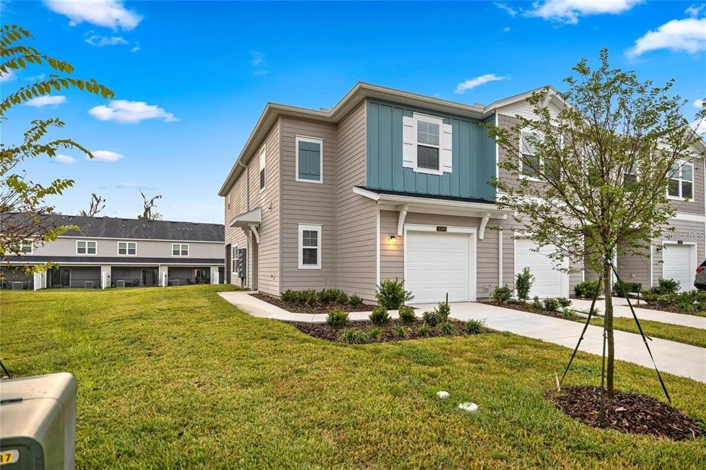 A two-story townhouse with light gray siding, a blue accent wall, and a white garage — 3644 SE 37TH COURT, OCALA, FL