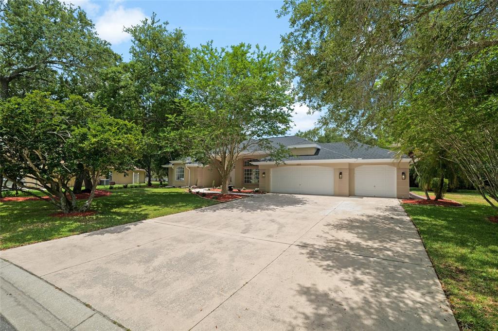 A single-story house with a three-car garage and a large concrete driveway — 3519 SANDBURG LOOP, PLANT CITY, FL