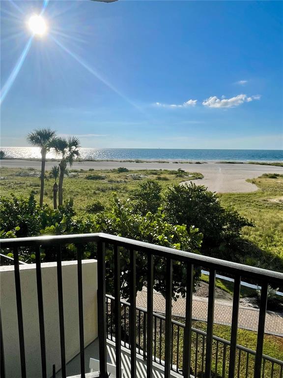A view from a balcony overlooking a sandy beach, dunes, and the ocean — 1290 GULF BOULEVARD UNIT 307, CLEARWATER, FL