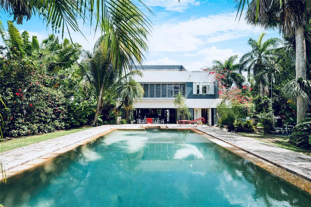 A rectangular swimming pool sits in front of a two-story white house surrounded by palm trees — 13 PEDROSA ST. GARDEN HILLS, GUAYNABO, PR