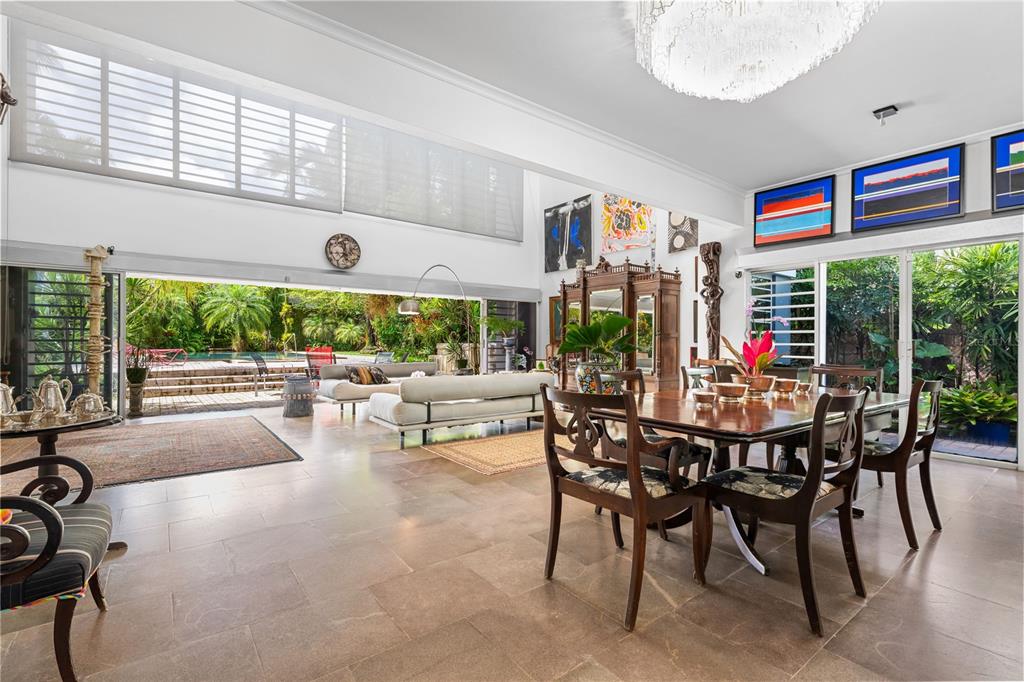 A spacious living and dining area with tile floors opens to a patio and pool — 13 PEDROSA ST. GARDEN HILLS, GUAYNABO, PR