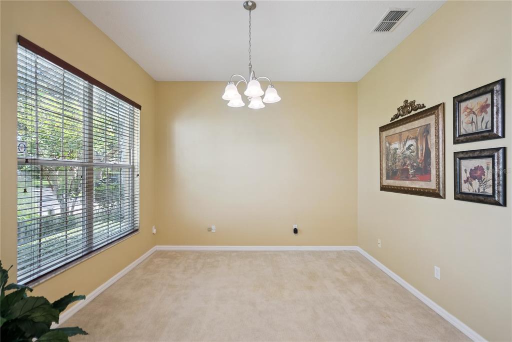 A dining room with beige walls, carpeted flooring, a chandelier, and framed wall art — 1040 KERSFIELD CIRCLE, LAKE MARY, FL