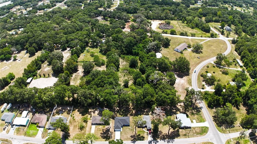 An aerial view shows a residential neighborhood with houses, dense trees, and a winding road — 6339 NW 52ND AVENUE, OCALA, FL