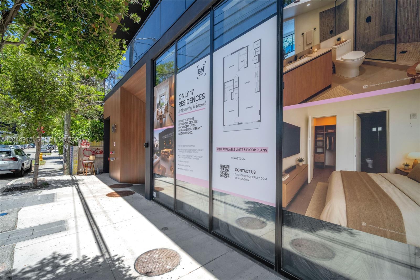 A glass storefront displays a floor plan and interior renderings of a modern residential building — 91 NW 27th St # 503, Miami FL 33127, MIAMI, FL